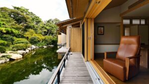 Relaxsessel neben einem zum Gartenteich offenen Zimmer