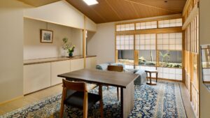 Tatami-Zimmer mit Tisch, Stühlen und Sitzplätzen am Fenster