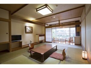 Habitación de tatami con mesa baja y sillas junto a la ventana