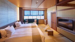 Letti singoli in una camera tatami con divano e finestra