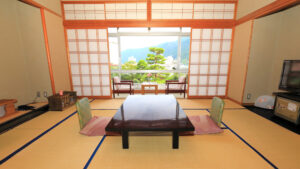 Habitación de tatami con mesa baja y sillas junto a la ventana