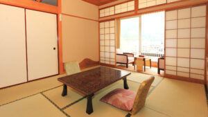 Habitación de tatami con mesa baja y sillas junto a la ventana