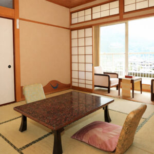 Habitación de tatami con mesa baja y sillas junto a la ventana