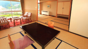 Habitación de tatami con mesa baja y sillas junto a la ventana