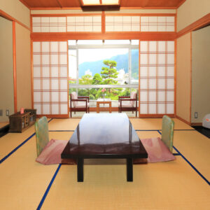 Habitación de tatami con mesa baja y sillas junto a la ventana