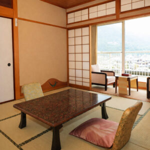 Habitación de tatami con mesa baja y sillas junto a la ventana