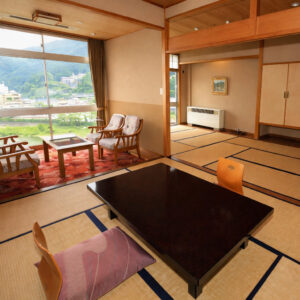 Habitación de tatami con mesa baja y sillas junto a la ventana