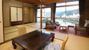 Habitación de tatami con mesa baja y zona de asientos junto a la ventana