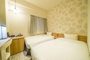 객실의 책상 옆에 놓인 트윈 침대