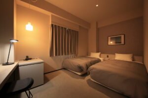 은은한 조명의 객실에 놓인 트윈 침대