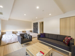 Guest room with sofa, armchair, and two beds