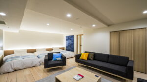 Guest room with three beds, sofa, and coffee table