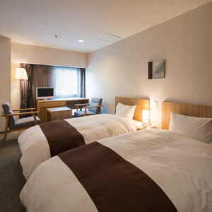 Twin beds in a guest room with chairs
