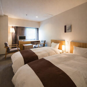 Twin beds in a guest room with seating area