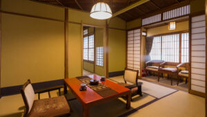 Tatami-Gästezimmer mit niedrigem Tisch und Stühlen