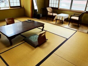 Camera in tatami con tavolo basso e sedie vicino alle finestre