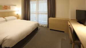 Letto matrimoniale accanto alla finestra e alla scrivania nella camera