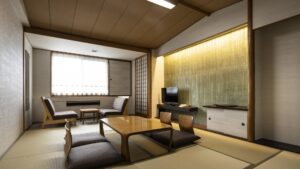 Camera in tatami con tavolo basso, sedie da pavimento e posti a sedere vicino alla finestra