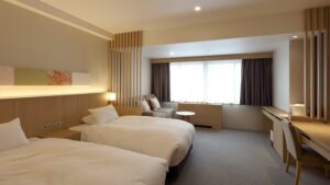 Letti singoli in una camera con scrivania e divano