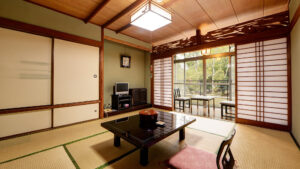 Habitación de tatami con mesa baja y sillas junto a la ventana