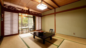 Habitación de tatami con mesa baja y sillas junto a la ventana