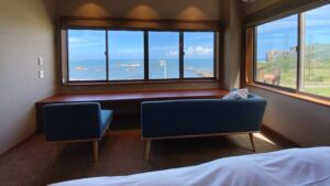 Divano e poltrona accanto alle finestre con vista sul mare