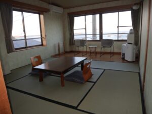 Camera in tatami con tavolo basso e sedie vicino alle finestre