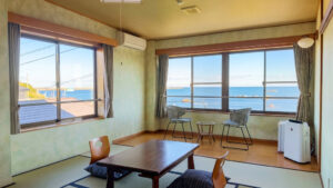 Camera in tatami con tavolo basso e sedie vicino alle finestre