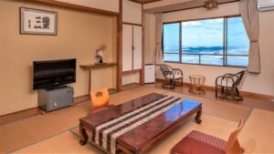 Camera in tatami con tavolo basso e finestra con vista sull’oceano