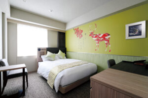 책상과 의자가 있는 객실의 더블침대