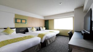 책상과 TV가 있는 객실의 침대 3개