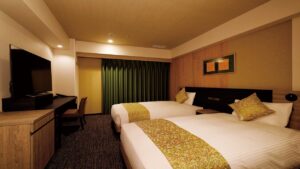 책상과 TV가 있는 호텔 객실의 트윈 베드