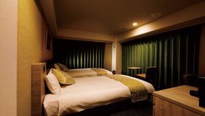 어두운 조명의 객실에 놓인 침대 두 개