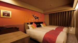 따뜻한 조명의 객실에 놓인 침대 두 개