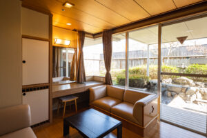 Guest room seating area beside large windows and garden view