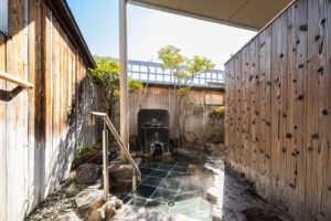 Private open-air bath with stone floor and wooden walls