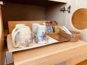 Tea mugs and packets on a room shelf