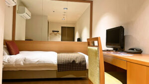 객실의 책상과 TV 옆 싱글 침대