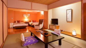 침대 옆에 낮은 테이블과 의자가 있는 다다미 객실