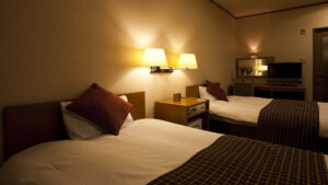침대 옆 램프가 있는 객실의 트윈 침대