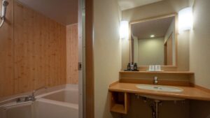 Lavabo y bañera con paneles de madera en la pared