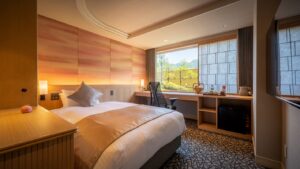 Dormitorio con cama doble y escritorio junto a la ventana