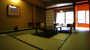 Habitación de tatami con mesa baja y sillas junto a la ventana