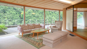 Sofá y sillas junto a grandes ventanales en una habitación de tatami