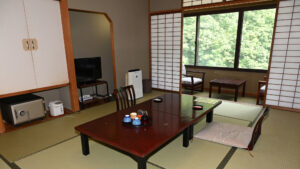 Habitación de tatami con mesa baja y zona de estar junto a la ventana