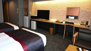 Camas individuales en una habitación con escritorio y TV