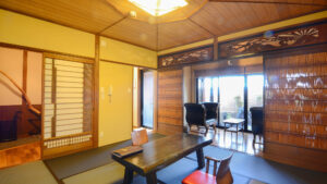 Habitación de tatami con mesa baja y sillas junto a la ventana
