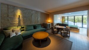 Zona giorno con divano, tavolo e sedie vicino alla finestra