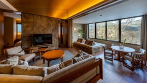 Zona giorno con divani, sedie e grandi finestre