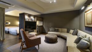 寝室のそばに曲線ソファと椅子を備えたリビングエリア